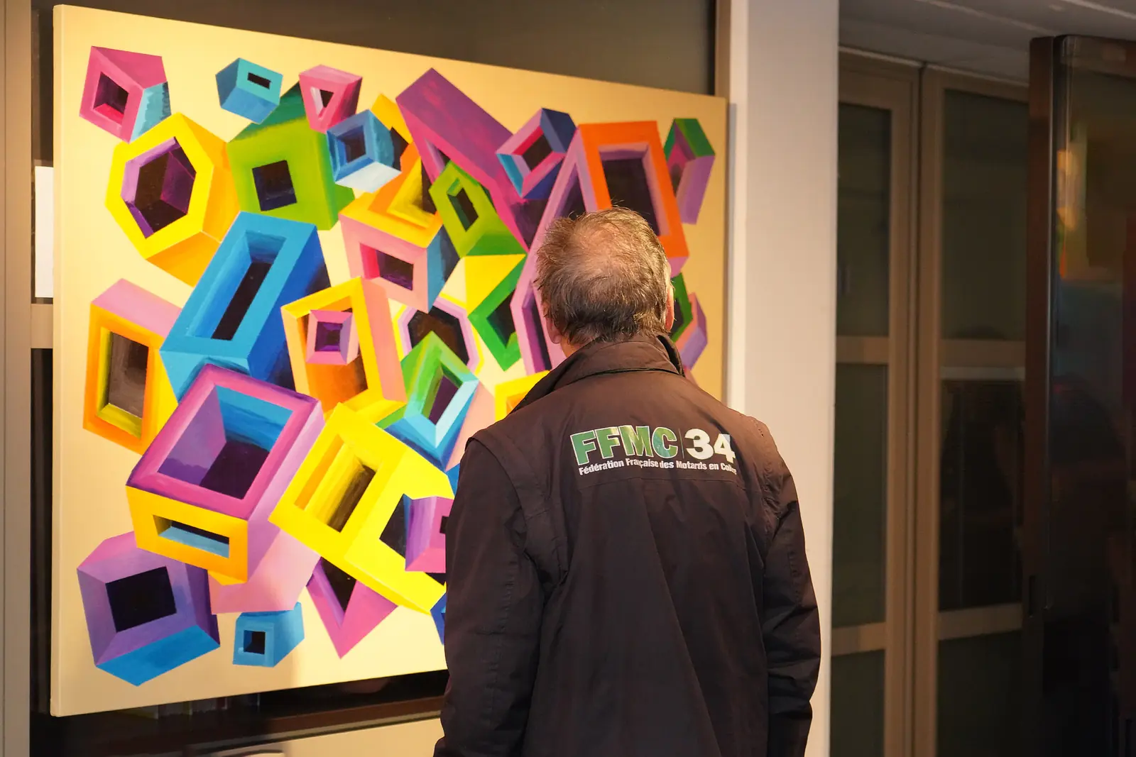 Une visiteuse devant une œuvre colorée